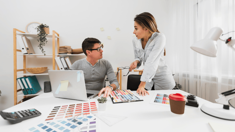 Designers collaborate on a Logo Design Ipoh project in a modern office.